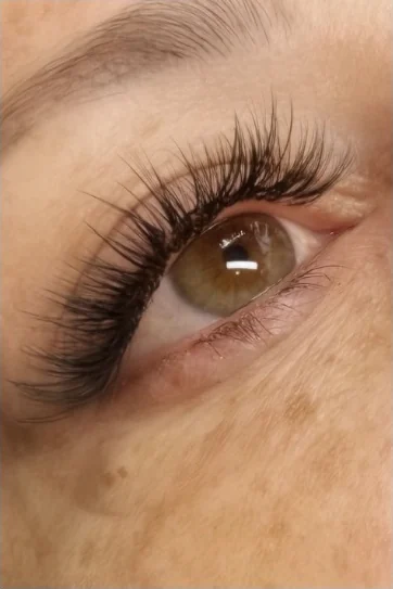 Open eye with a full volume lash set, lashes fanned and tapered to the outer corner